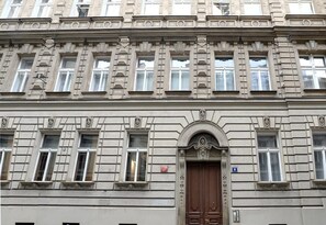 Un edificio de varios pisos con detalles arquitectónicos clásicos, incluyendo marcos de ventanas ornamentados y molduras decorativas.