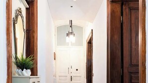 A hallway with a wooden floor, white walls, and a white door at the end. - Imperial Deluxe Suite (Prague)