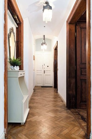 A hallway with a wooden floor, white walls, and a white door at the end. - Imperial Deluxe Suite (Prague)