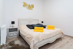 Une chambre à coucher avec un lit, des tables de chevet et un élément décoratif mural.