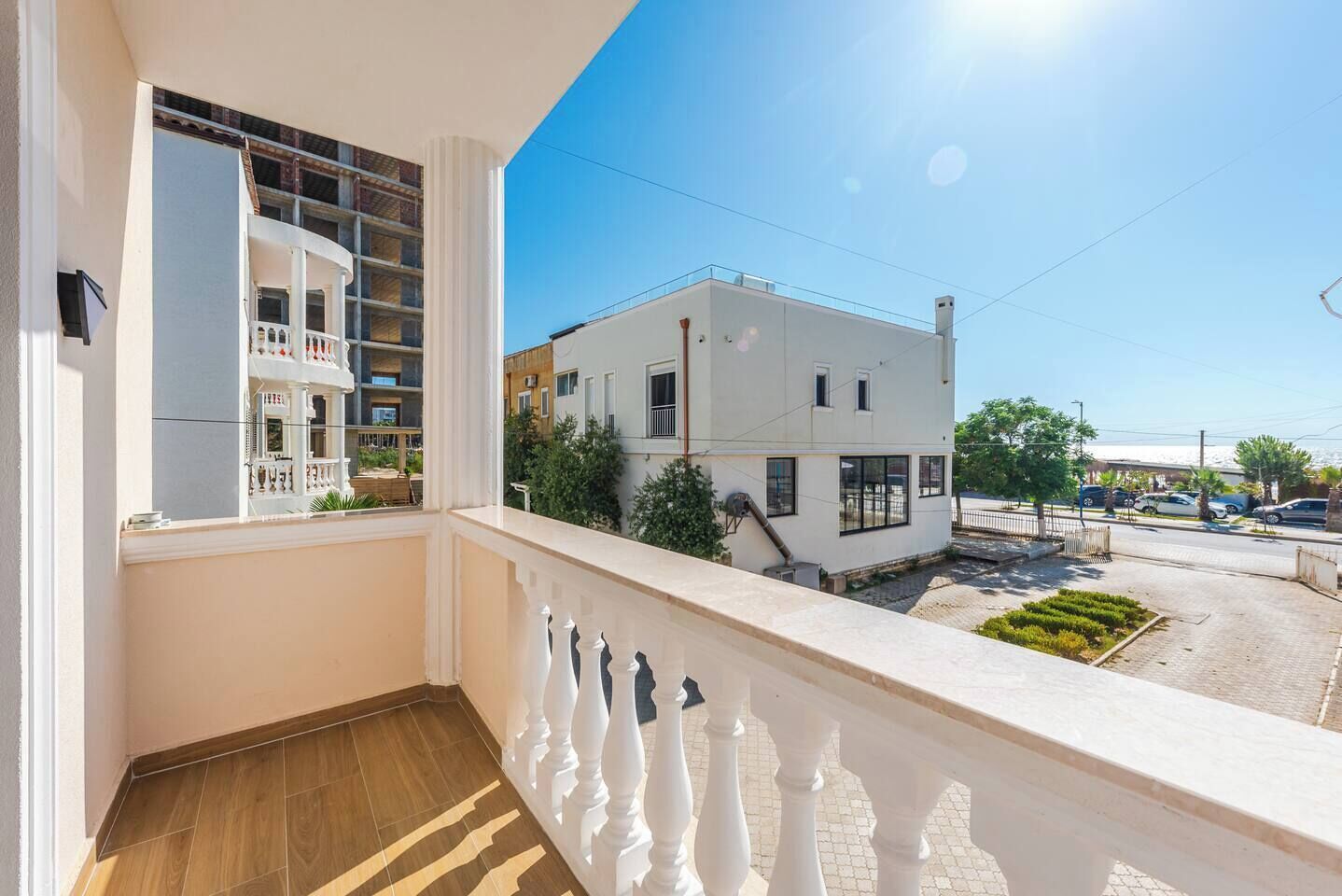 Un balcón con vistas a un edificio residencial y una calle.