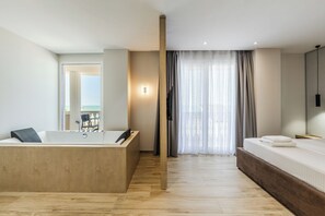Un dormitorio moderno con una bañera de madera, una cama grande y vistas al mar a través de cortinas translúcidas.