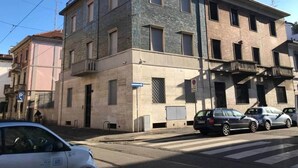 A multi-story building with a parking area in front.