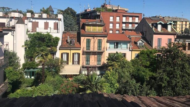 A row of multi-story buildings with balconies, surrounded by lush greenery. - milan downtown appartment, porta venezia (Milano)