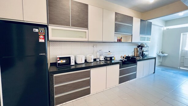 A modern kitchen with a black refrigerator, white and brown cabinets, a black countertop, and a tiled floor. - myRoom at 14 J Mandalay (George Town)
