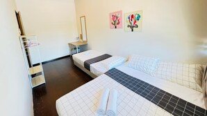 A hotel room with two beds, a desk, a mirror, and artwork on the wall. - myRoom at 14 J Mandalay (George Town)
