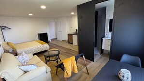 Eine moderne Wohnung mit Bett, Sofa und Essbereich, inklusive Küche und Badezimmer.