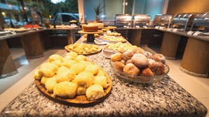 A buffet with various food items including pastries and bread. - Pousada Itajuipe (Itabuna)
