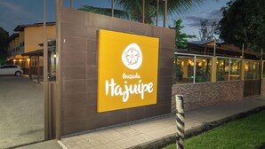 A building with a large yellow sign reading "Pousada Tajujepe". - Pousada Itajuipe (Itabuna)