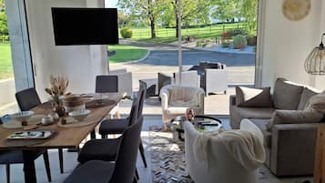 Casa conforto, vista para o jardim | Área de estar | TV LED 102 cm com canais digitais