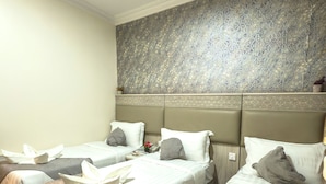 Une chambre d’hôtel avec deux lits, chacun équipé d’une tête de lit, d’oreillers et d’une couverture.