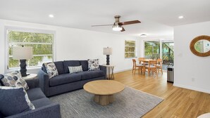 A modern living room with a sofa, coffee table, and dining area.