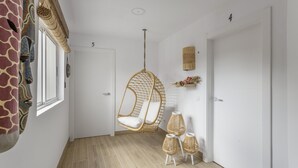 Een hal met een hangstoel, rieten lampen en een wanddecoratie met girafdessin.