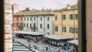 A bustling outdoor market with various stalls and people. - Borgo di Lazise (Lazise)
