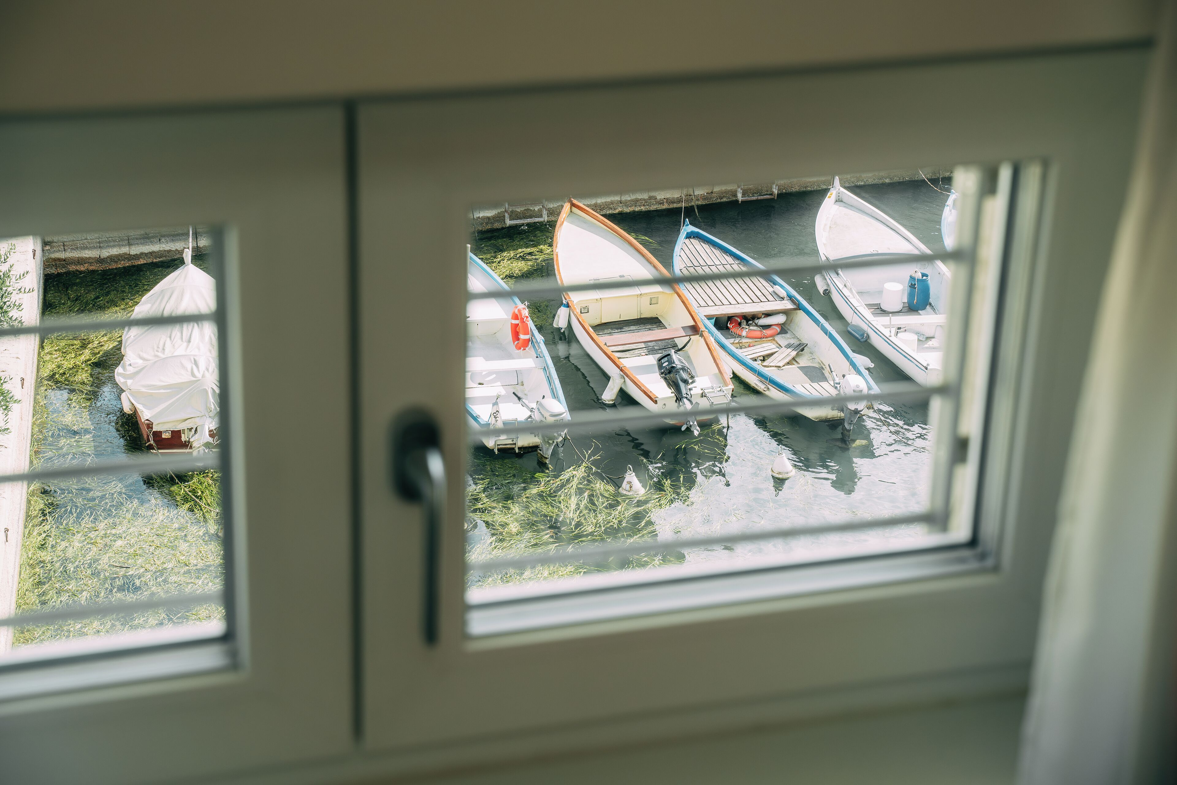 A view through a window of several boats docked at a marina.