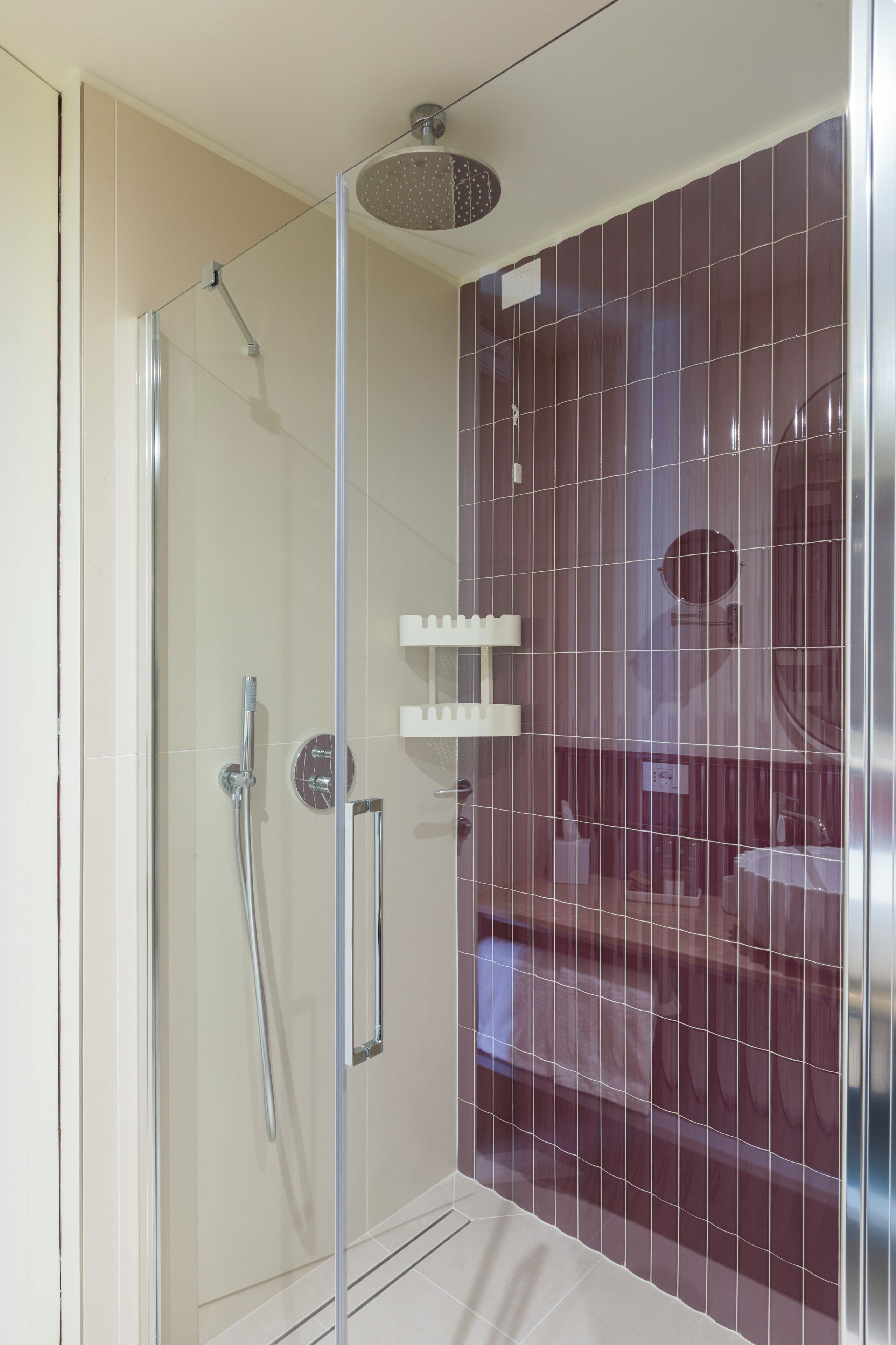 A modern bathroom with a glass-enclosed shower, a white towel rack, and a mirror.