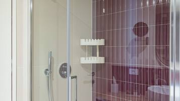 A modern bathroom with a glass-enclosed shower, a white towel rack, and a mirror.