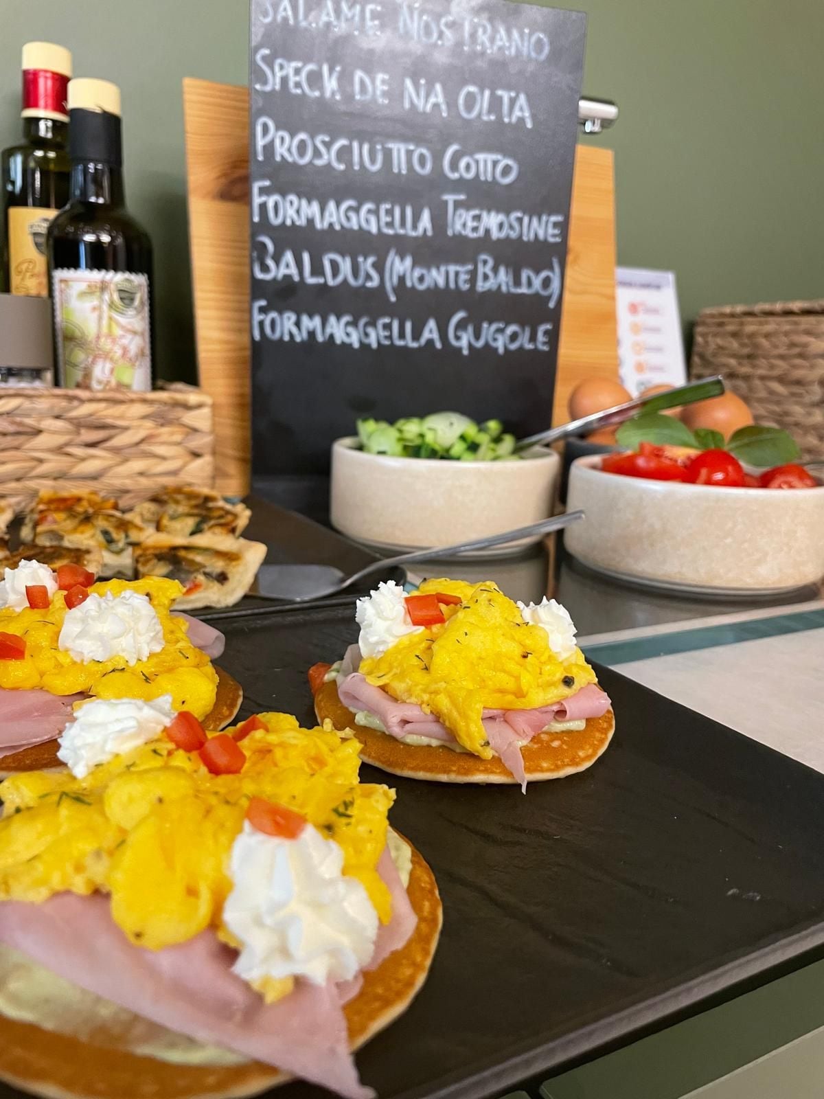 Un bufé de desayuno con diversos alimentos y un menú al fondo.