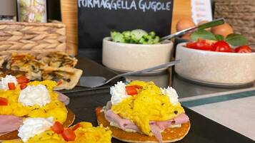 Un bufé de desayuno con diversos alimentos y un menú al fondo.