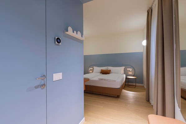 A hotel room with a bed, bedside table, and a wall-mounted thermostat. - Borgo di Lazise (Lazise)