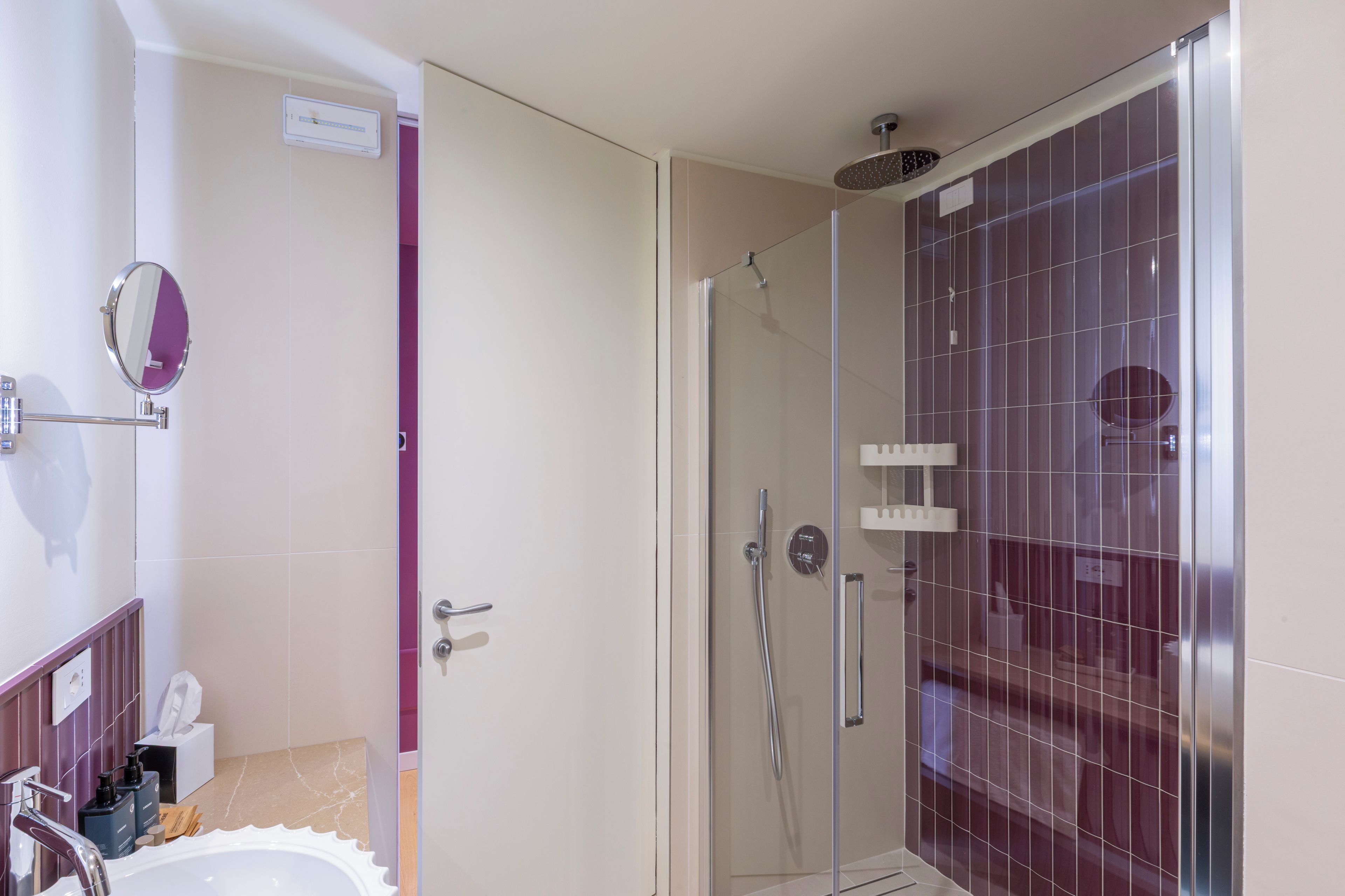 Un baño moderno con ducha, espejo y lavabo.