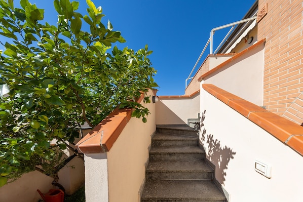A staircase leading up to a building with a clear blue sky above.