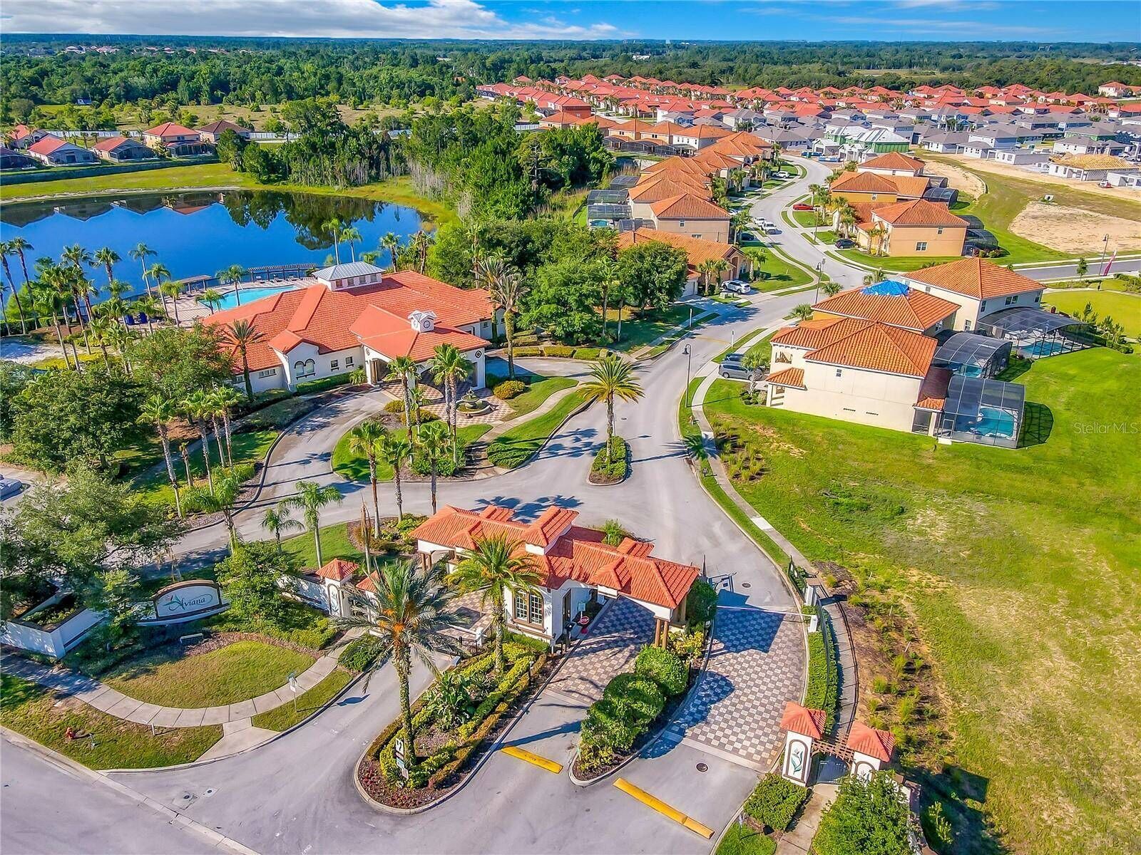An aerial view of a residential area with houses, a swimming pool, and a well-maintained landscape.