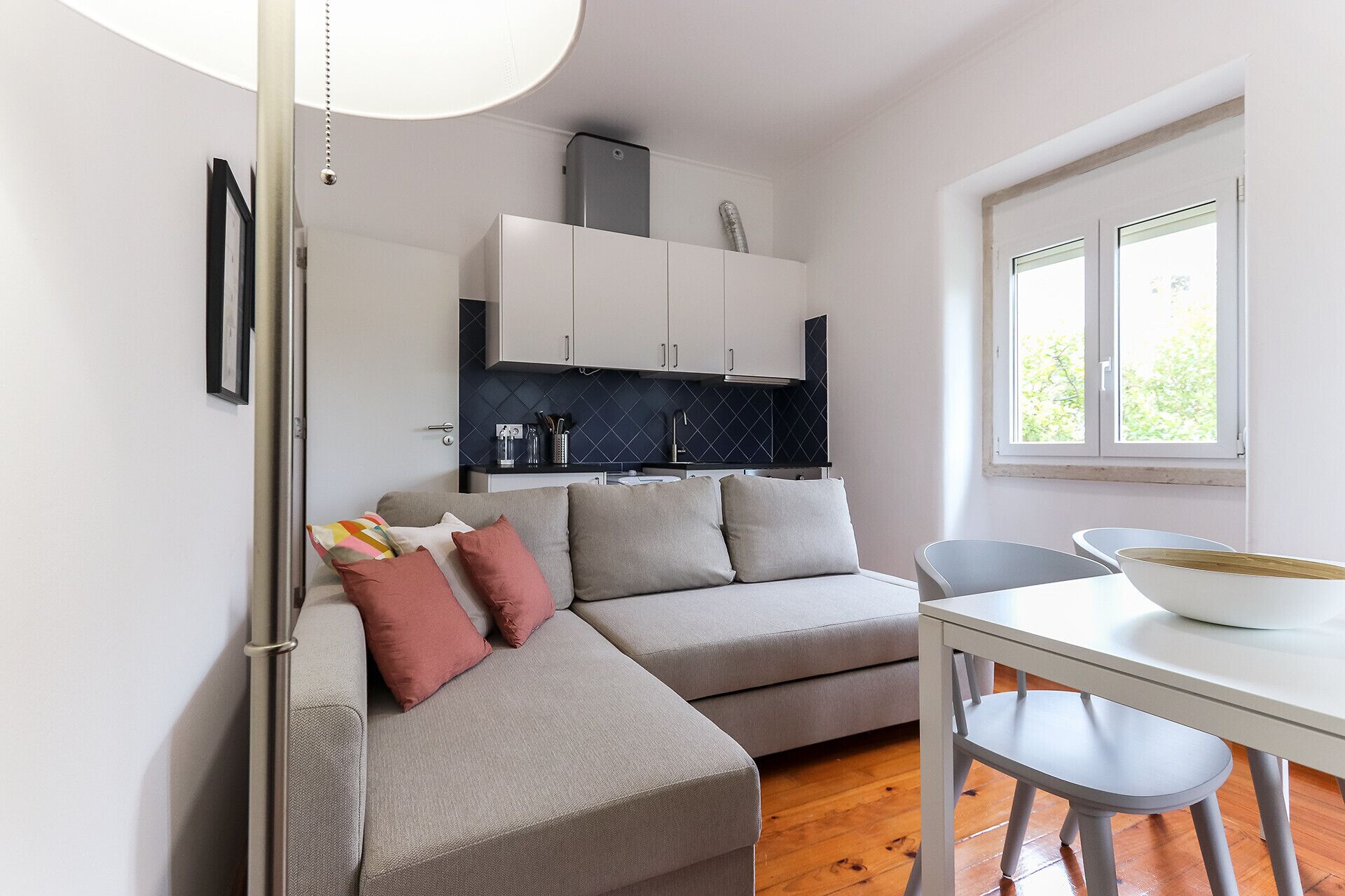 A compact living space with a sofa, a dining table, and a kitchenette.