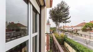 Un balcon donnant sur une rue et des maisons.