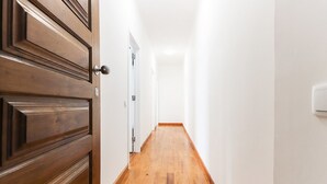A narrow hallway with wooden flooring and white walls. - Belem Boutique IX by Homing (Lisbon)