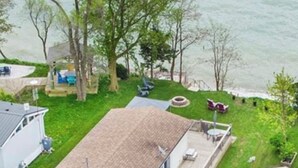 Una casa de un piso con un porche delantero, una pequeña terraza y un garaje.