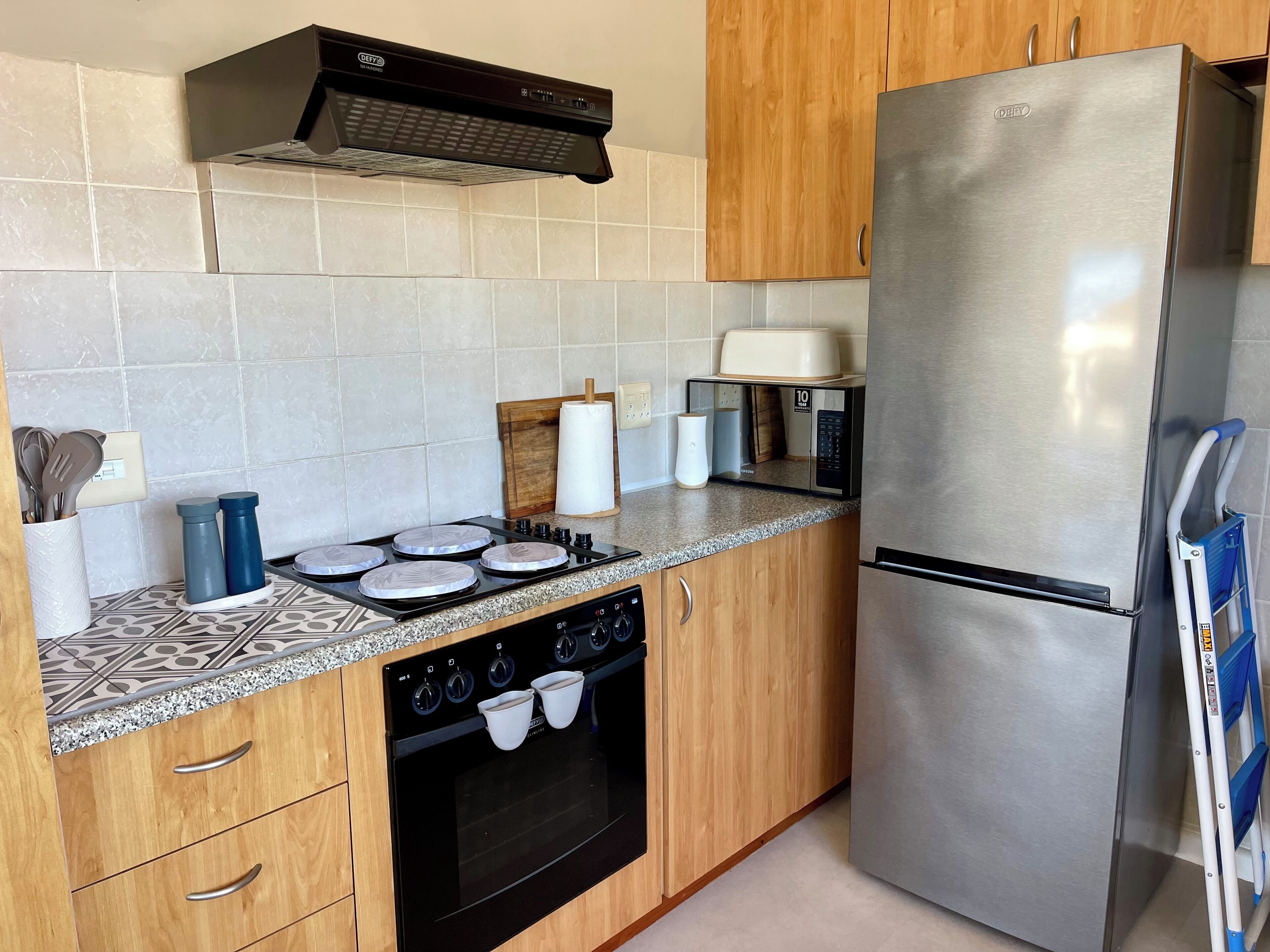 A modern kitchen with a stainless steel refrigerator, a built-in oven, and a gas stove.