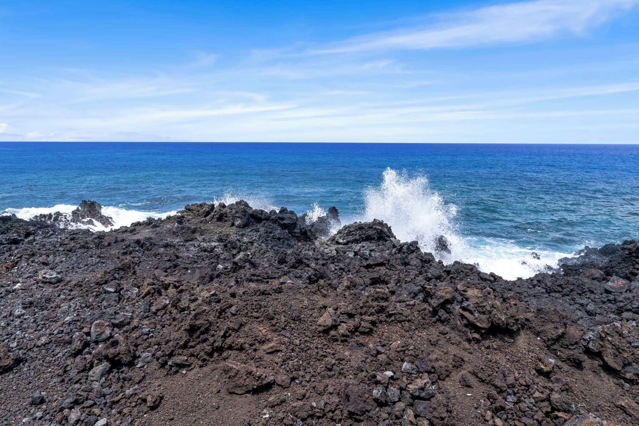 A rocky coastline with waves crashing against the shore.