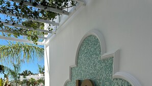 Fachada de un edificio con un gran muro de mosaico y un llamativo logotipo 'C'.