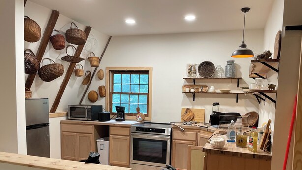 A kitchen with wooden cabinets, a microwave, a coffee maker, and various kitchen utensils. - Berkshires Barn Stay on Working Homestead  (West Stockbridge)