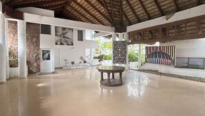 Un vaste espace intérieur doté d’un haut plafond et d’un sol carrelé.