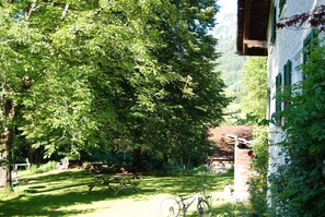 A garden with a picnic table, a bicycle, and a building with green shutters. - Chalet on the edge of the forest with a view of the waterfall right next door (Glarus Süd)