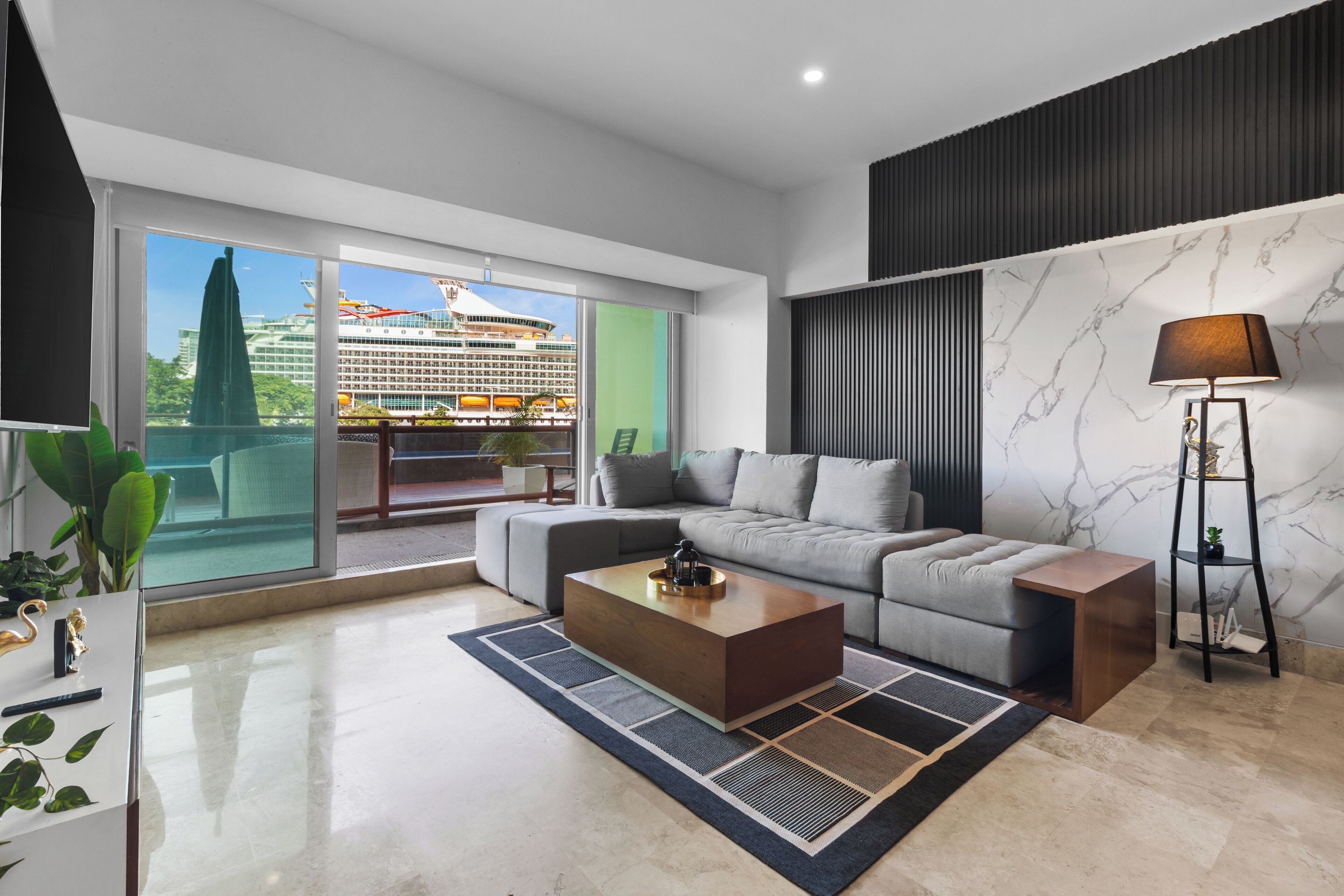 A modern living room with a grey sofa, a wooden coffee table, and a floor lamp.