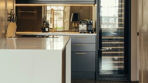 A modern kitchen with dark cabinetry, a large island, and pendant lighting.
