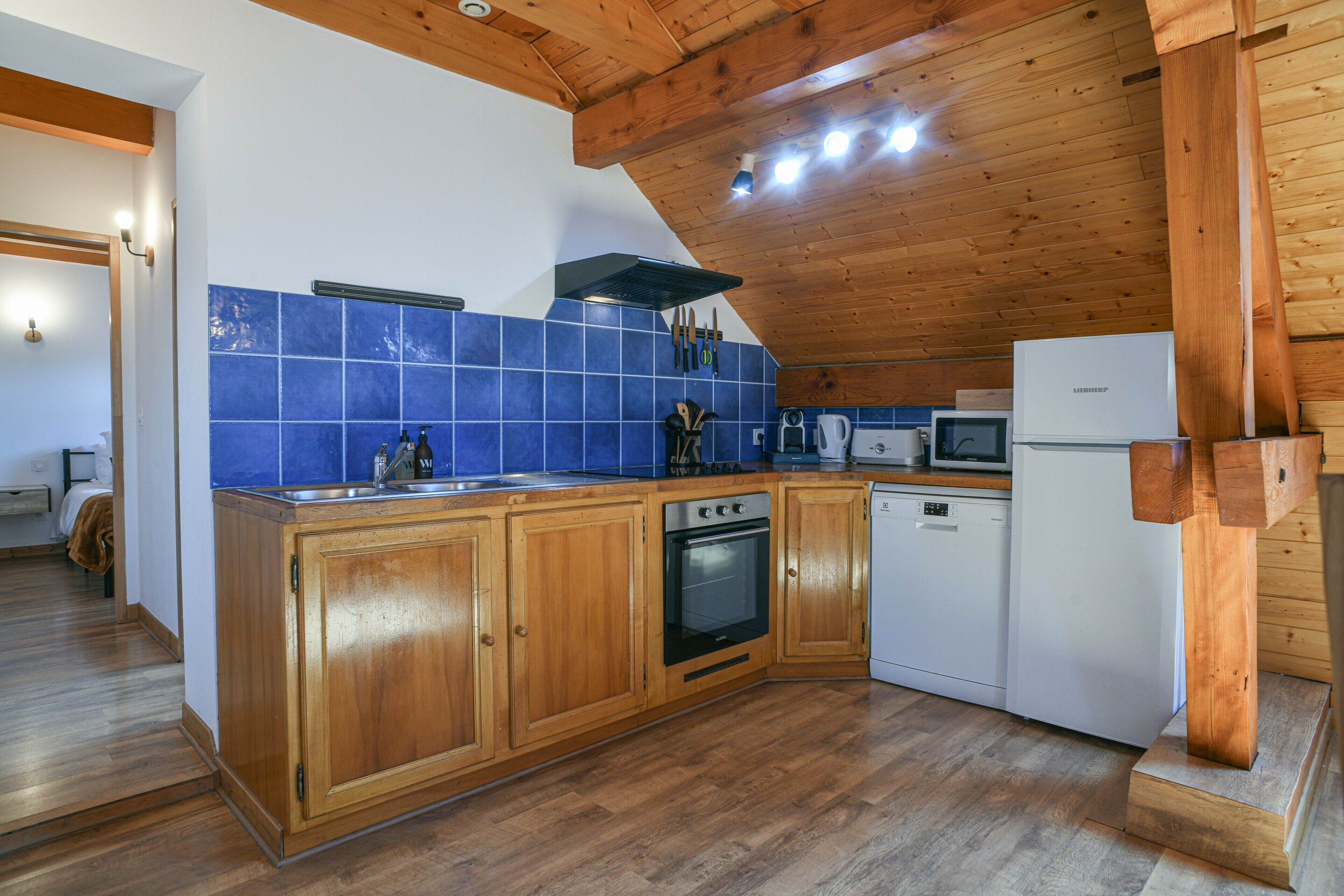 Una cocina con gabinetes de madera, estufa, microondas y lavavajillas.