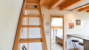 A wooden ladder leading to a door, a sign with 'CAFE PARIS' text, and a bar area with stools. - Chez Fred 201 – Parking, Wi-Fi, Near Savoie College (Saint-Pierre-d'Albigny)