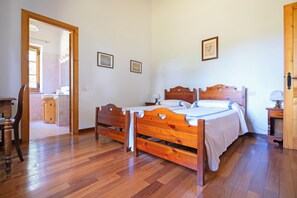 A bedroom with a wooden bed, a wooden nightstand, and a wooden chair. - ORZALUME FARMHOUSE (Umbria)