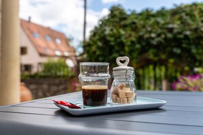 A table with a glass jar, a small glass cup, and a jar of sugar cubes.