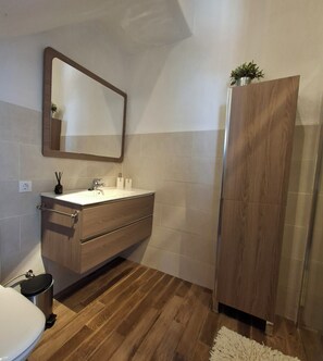 A bathroom with a wooden vanity, a mirror, a sink, and a toilet. - Molino Mairena villa in the middle of nature with heated pool (Montefrio, provincie Granada)