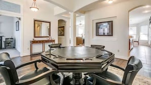 A spacious dining area with a large oval table and six chairs, surrounded by white walls and wooden flooring. - Charming house with AC and fitness room in enjoyable Fort Worth (Fort Worth)