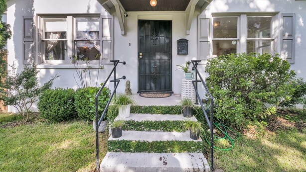A house with a black front door, white trim, and a small porch with steps. - Downtown Bungalow with Fenced Yard, Walkable to Restaurants, Dog Friendly (Charleston)
