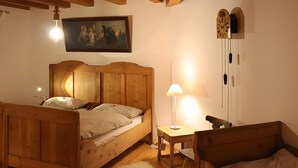 Une chambre à coucher en bois, avec un lit, une table de chevet, une lampe et un tableau au mur.