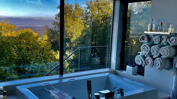 A modern bathroom with a large bathtub, a glass shower enclosure, and a view of trees and mountains. - Fantastic 7-bedroom house with AC in Los Altos Hills (Los Altos Hills)
