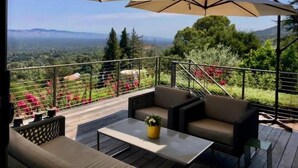 A terrace with outdoor seating, a table, and umbrellas. - Fantastic 7-bedroom house with AC in Los Altos Hills (Los Altos Hills)
