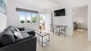 Una sala de estar moderna con sofá, mesa de centro y zona de comedor.